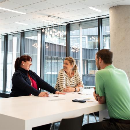 Three Texas Executive Education students talk at a table