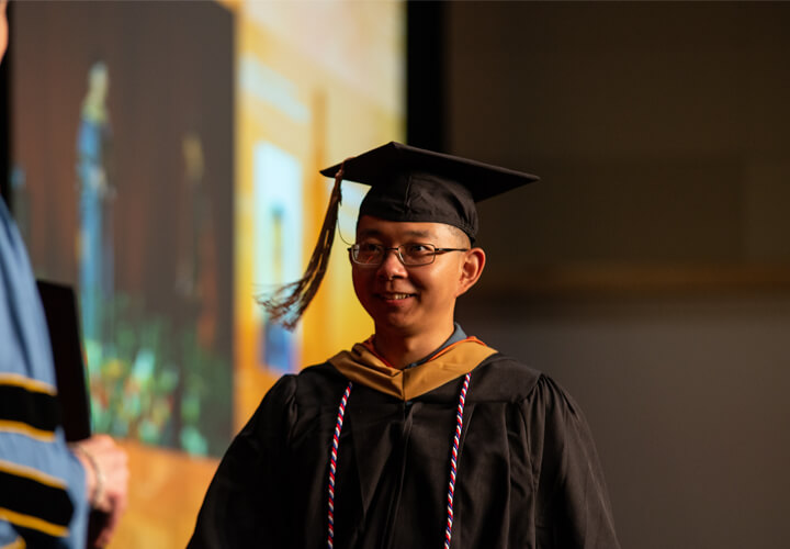 Smiling graduate in cap and gown