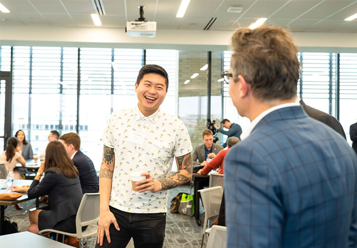 Two event attendees laugh over coffee