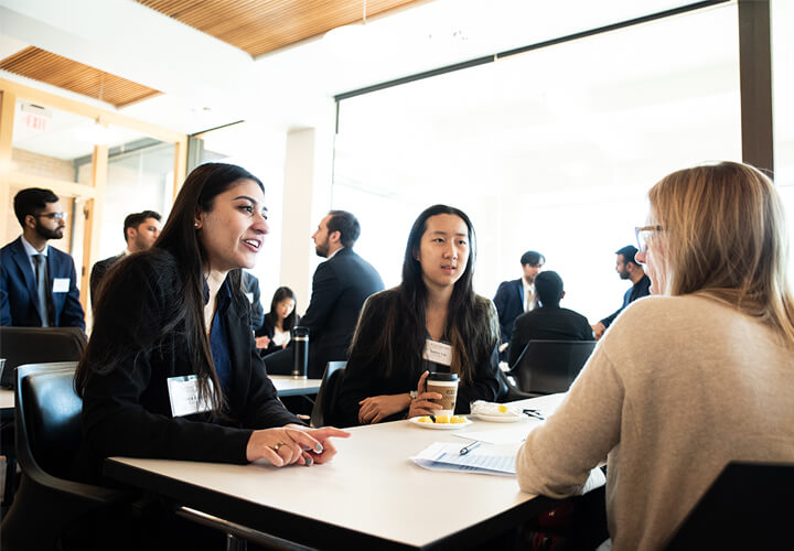 Event attendees speak together at a table