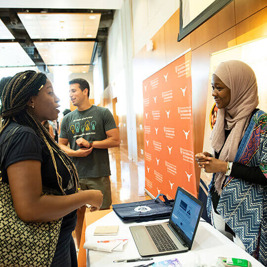 Event attendee speaks with vendor at booth