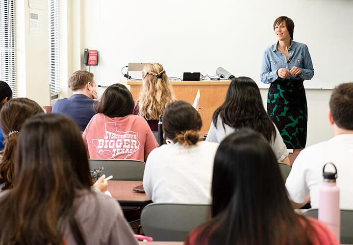 Instructor stands at front of class teaching