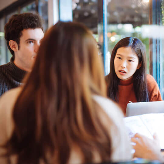 Three people collaborate at a table