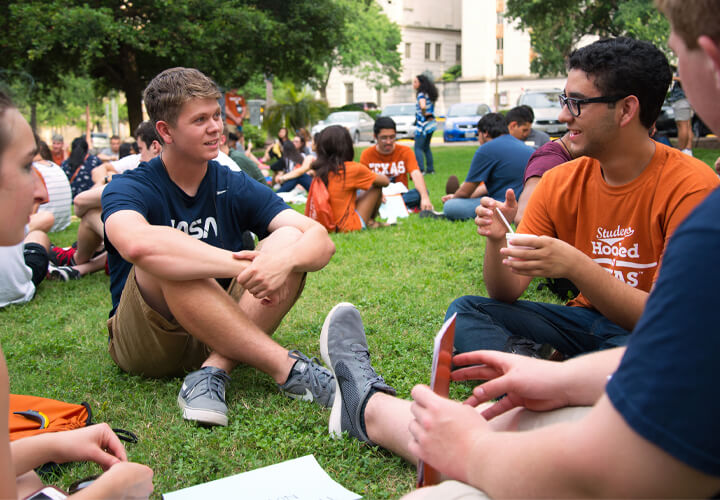 Students sitting in a circle on lawn