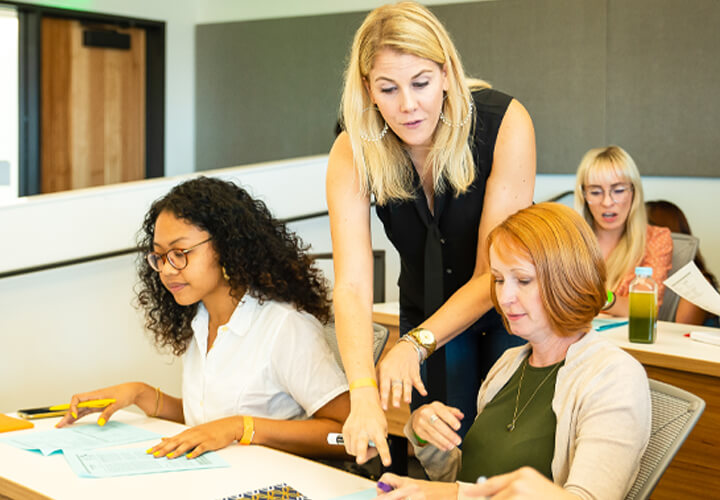 Instructor confers with two students in class