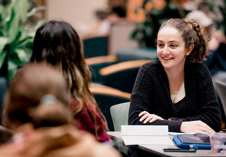 Students talk together at a table