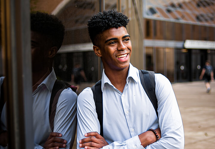 Smiling student stands outside GSB building