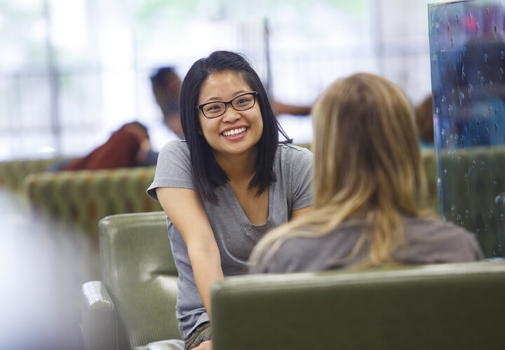 Two talking students sit together