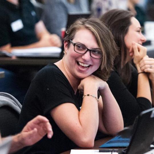 MBA students smile and talk together.