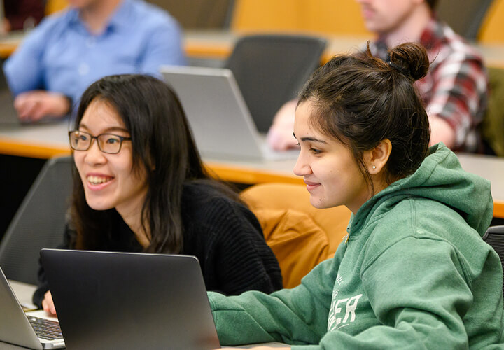 Two MS Program students smile in class