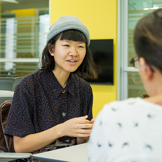 Two students talk in lab