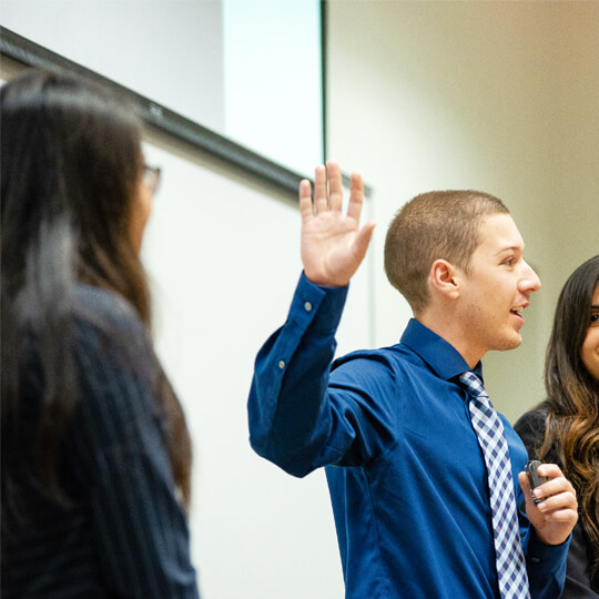 Four students speaking at front of healthcare class