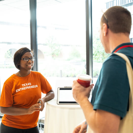 Two startup week attendees speak in Rowling Hall lobby