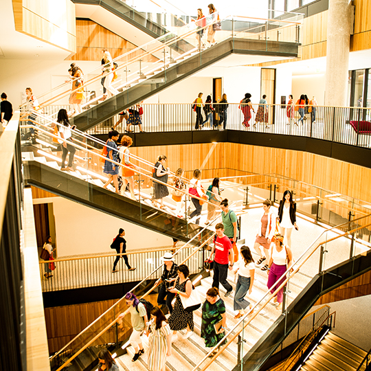 Students walk down the stairs in Rowling Hall