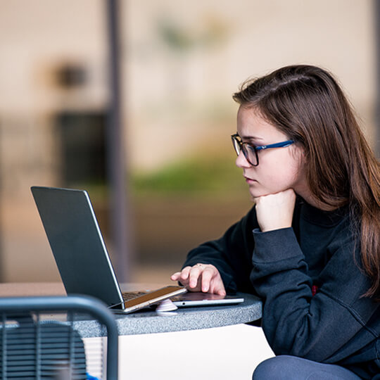 Student works on laptop at a table