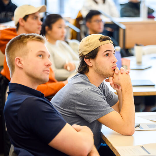 Two MS Program students listen in class