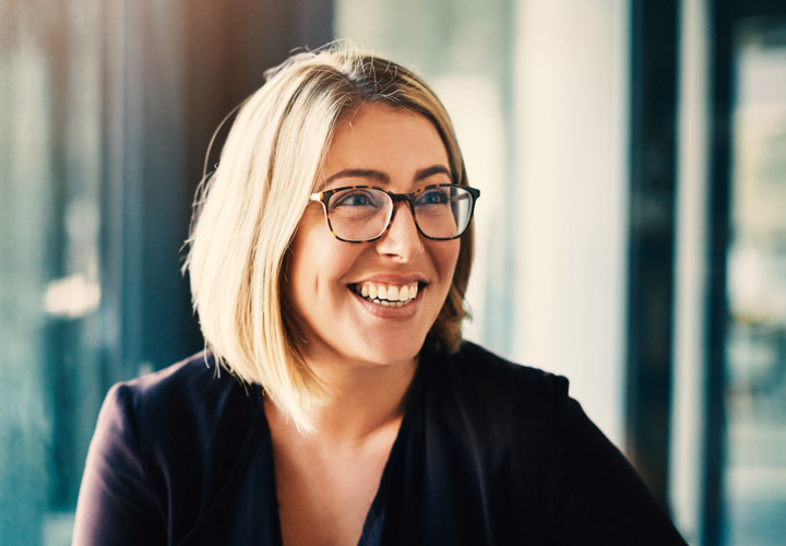 Woman in classroom setting smiling.