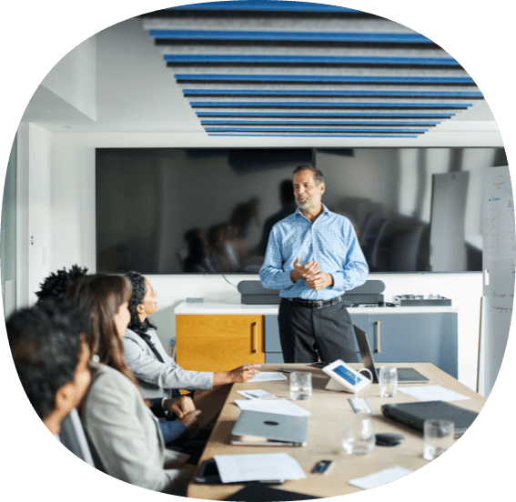 Man standing in front of conference table in office.