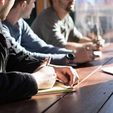 Desk with sunlight and hands of employees.