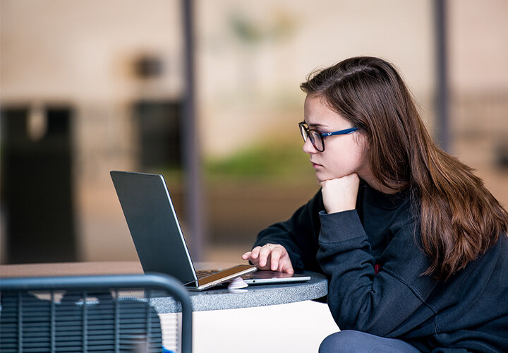 Student works on laptop at a table