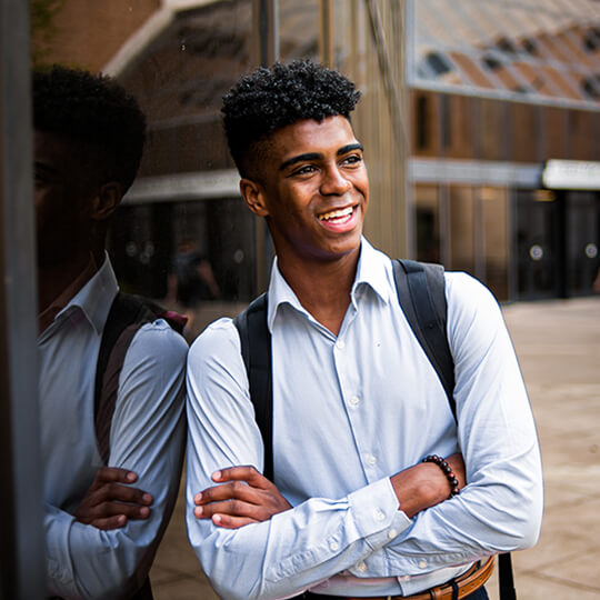 Smiling student stands outside GSB building